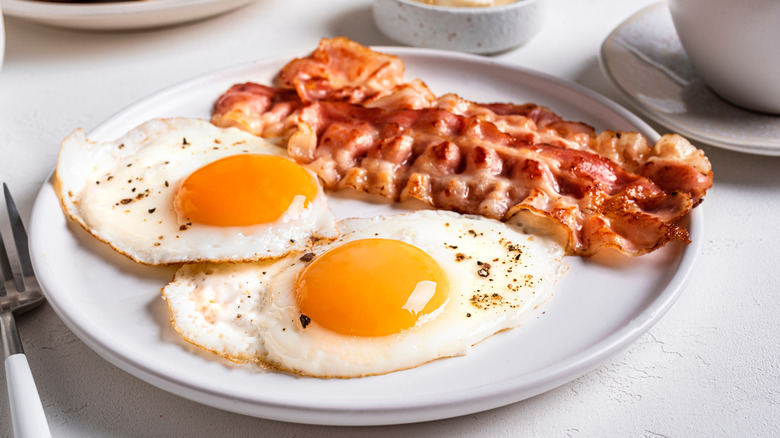 Plate with two fried eggs and strips of bacon