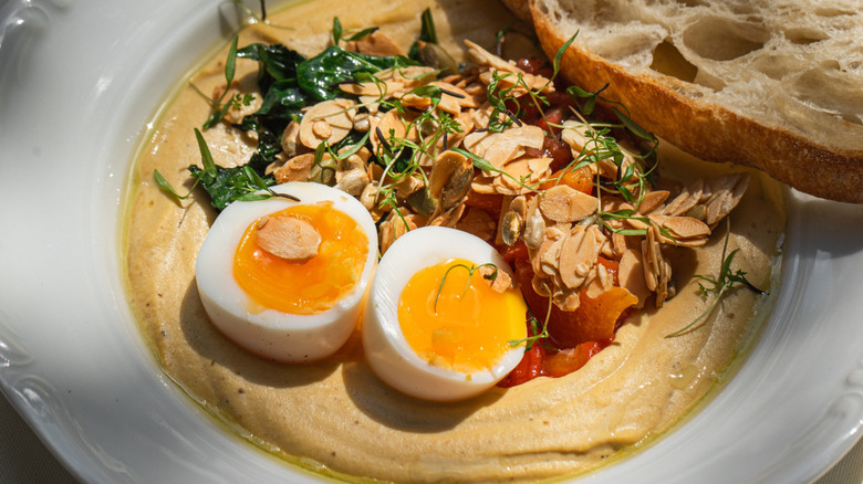 Bowl of hummus with egg and toast