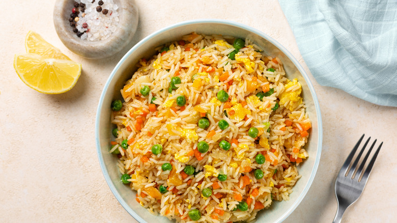 bowl of fried rice studded with peas and carrots