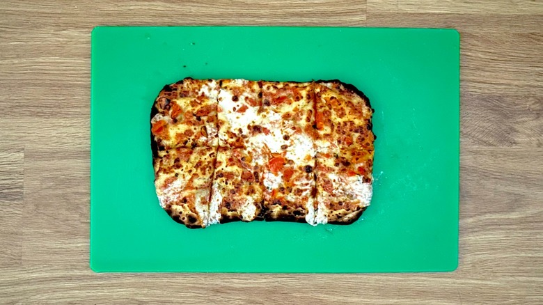 Baked Neapolitan-style pizza on a green cutting board