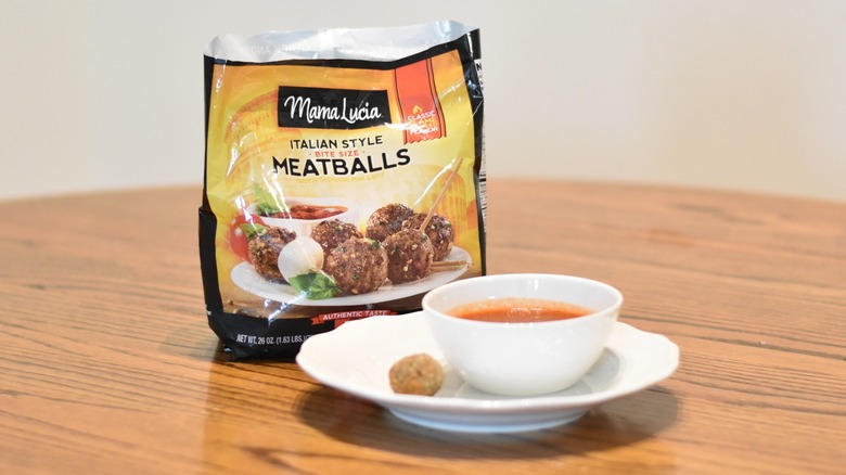 A bag of Mama Lucia meatballs next to a meatball and marinara on a white plate