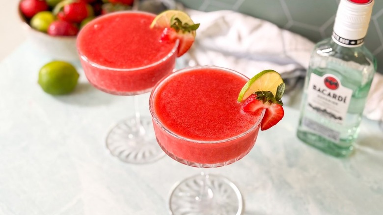 Top view of frozen strawberry daiquiris with strawberry and lime garnish