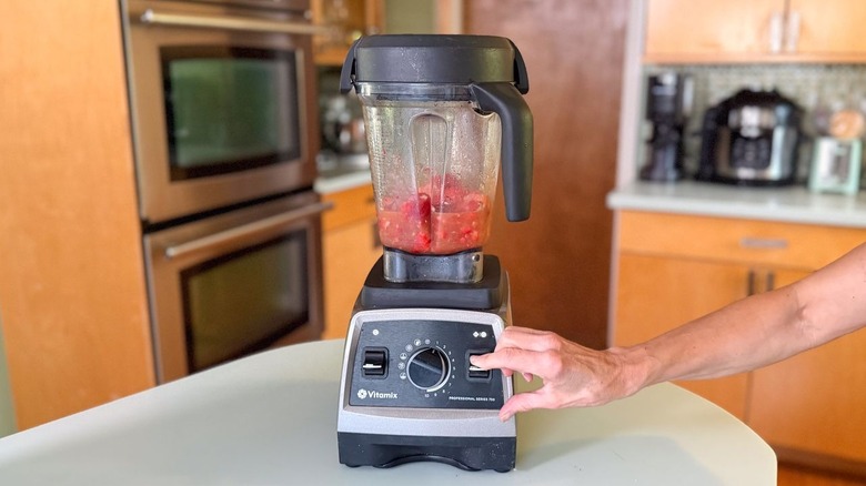 Pulsing high-speed blender with frozen strawberry daiquiri ingredients