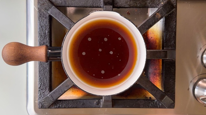 Turbinado sugar and water in a small saucepan on stovetop