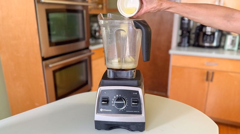 Adding lime juice ice cubes to blender pitcher