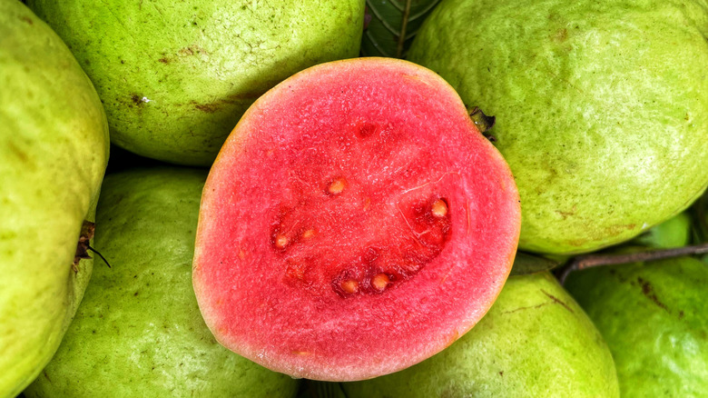 Sliced guava surrounded by whole guava