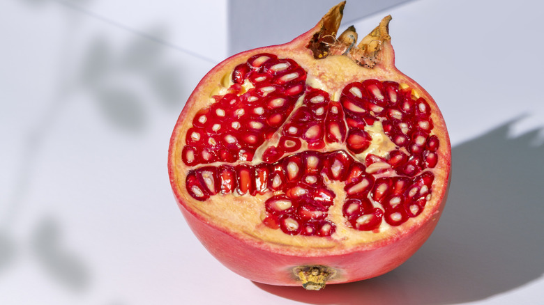 Pomegranate sliced in half on a white background