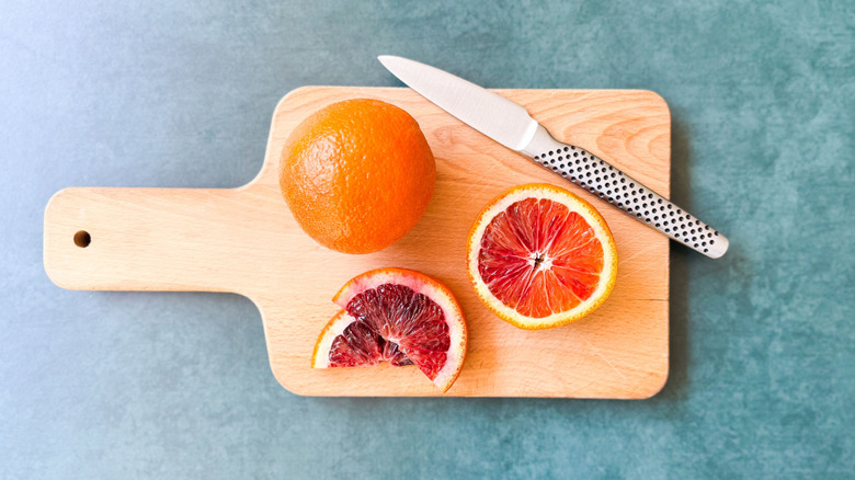 Blood oranges on cutting board with knife