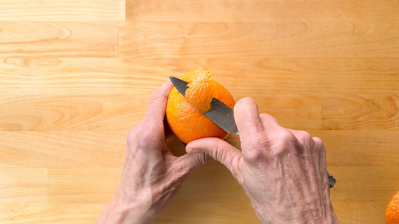 Removing zest from blood orange with paring knife