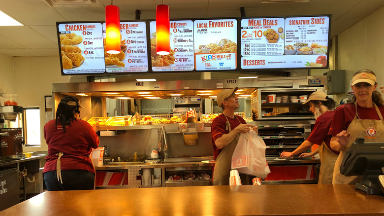 Popeyes employees working at counter.