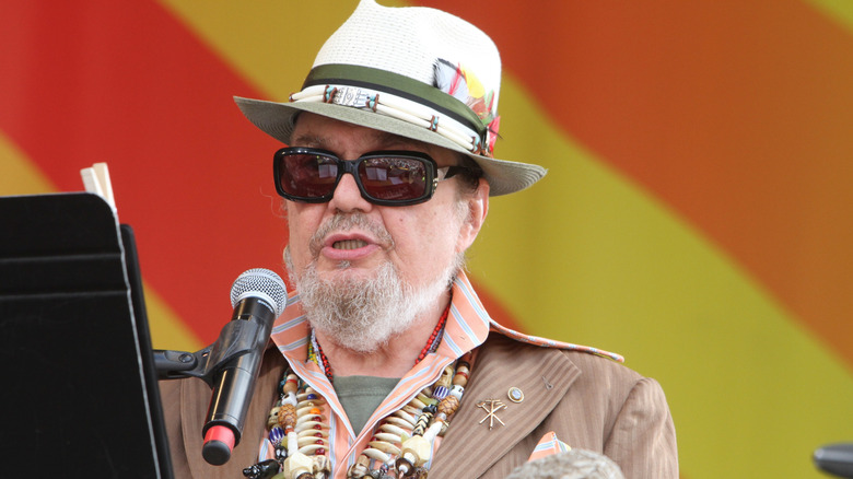 Dr. John wearing sunglasses and singing into microphone.