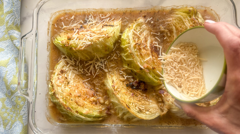 hand adding parmesan to baking dish
