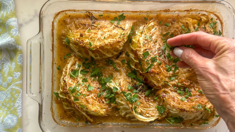hand adding parsley to dish