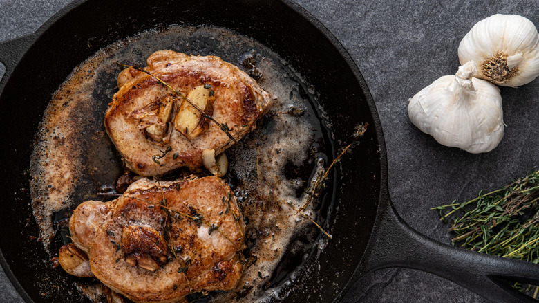 Pork in a pan with garlic and herbs