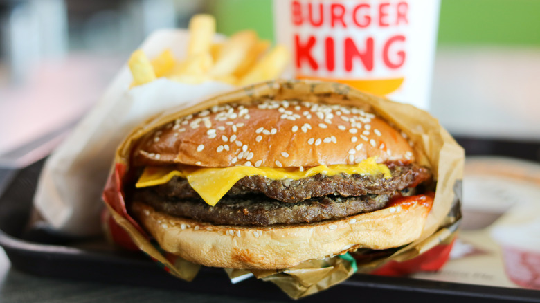 Closeup of a Burger King packet meal set featuring a double cheeseburger, french fries, and a drink.