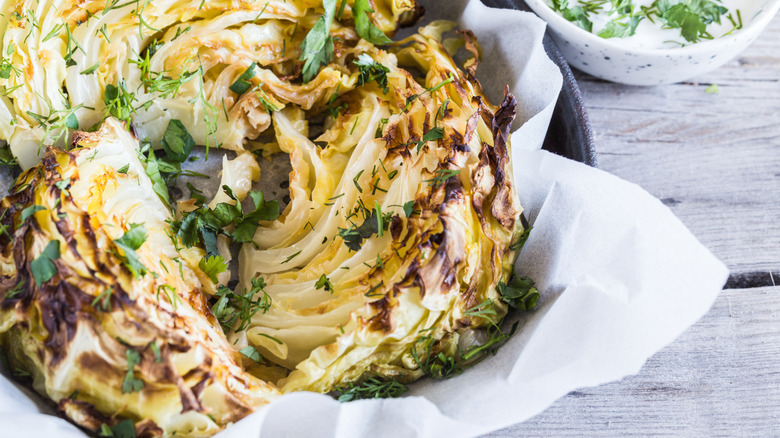 Healthy grilled cabbage steaks with sauce, spices and herbs.