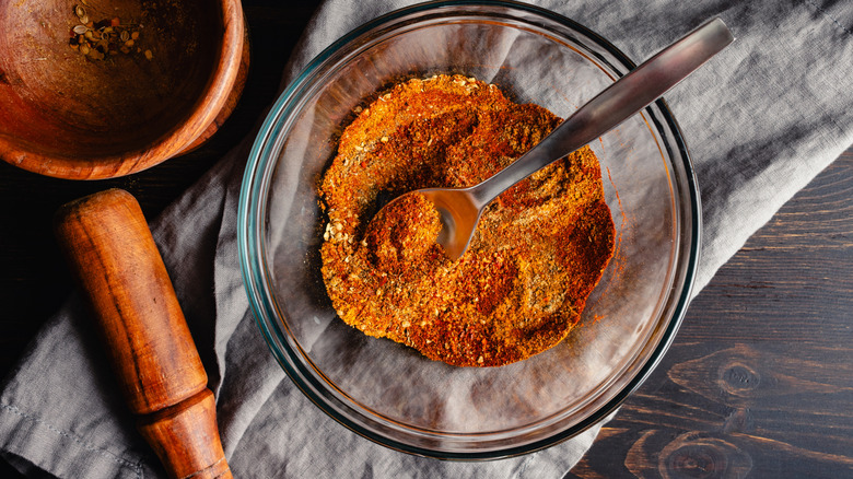A red spice blend in a bowl, with a spoon scooping it up