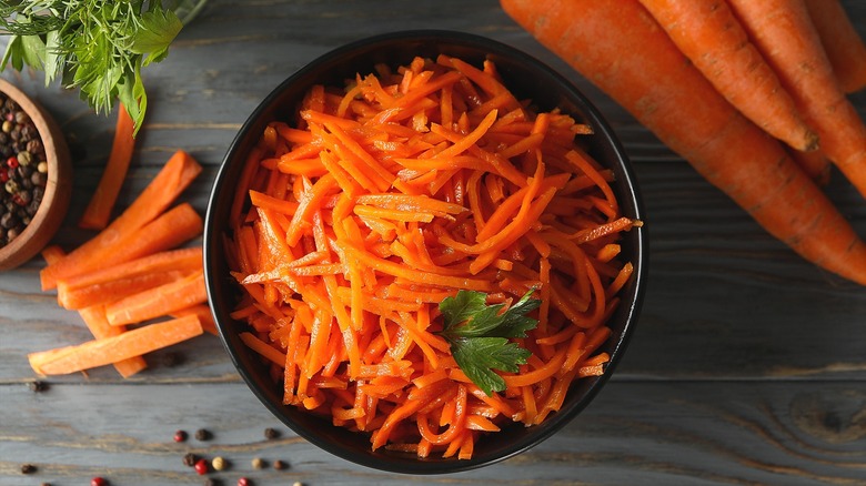 Top-down view of shredded carrots in a black bowl