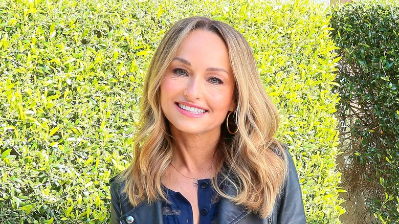 Giada De Laurentiis smiling in gold hoop earrings and a black leather jacket