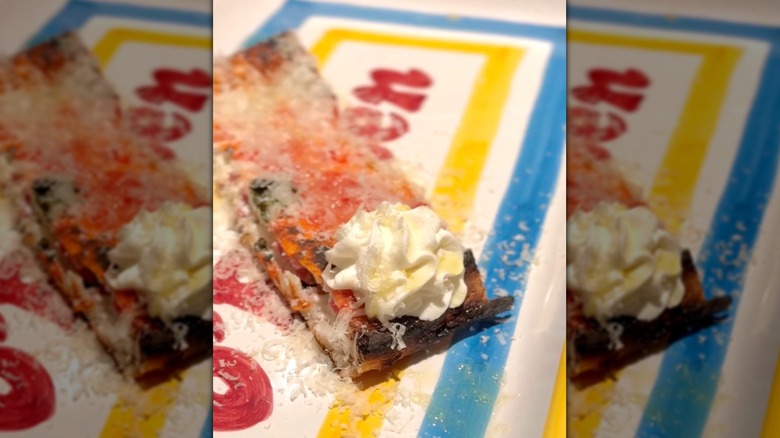 a close up slice of pizza with ricotta