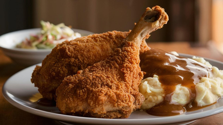 pieces of fried chicken and gravy over mashed potatoes