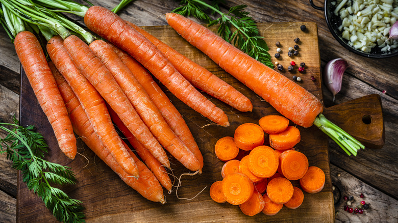Overhead view of whole carrots on a cutting board