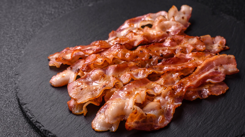 crispy cooked bacon on a black plate