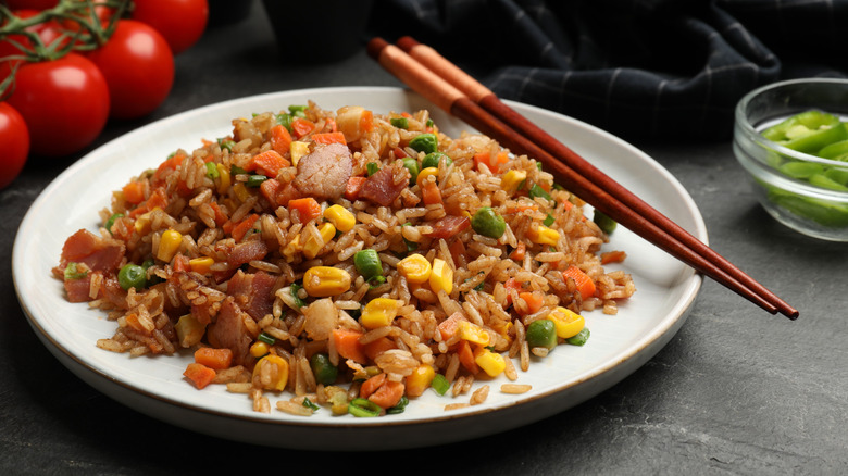 fried rice on a white plate with veggies