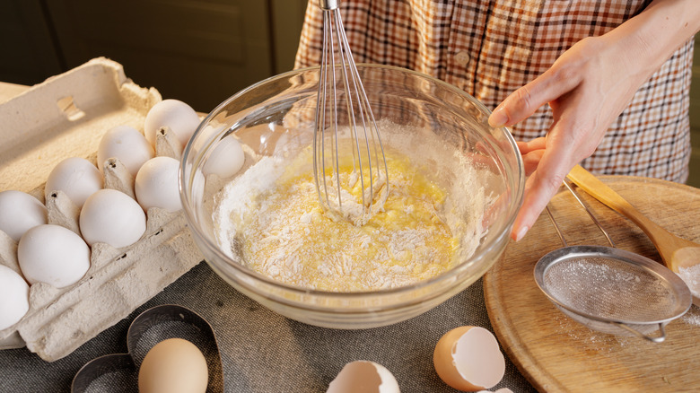 woman mixing cake batter in a glass bowl