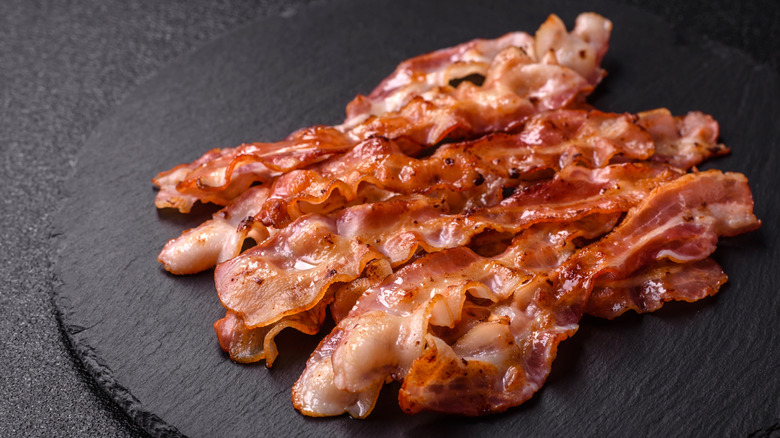 Rashers of crispy bacon on a black slate