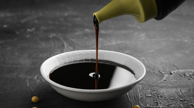 Soy sauce pouring into a white dish