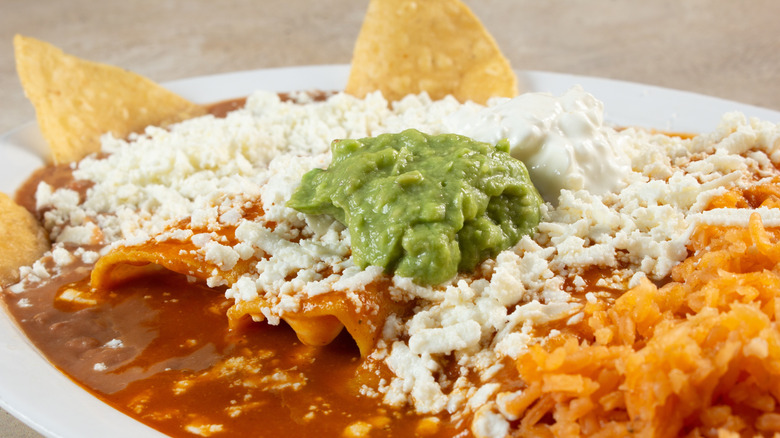 enchiladas dressed with sauce, cheese, and guacamole