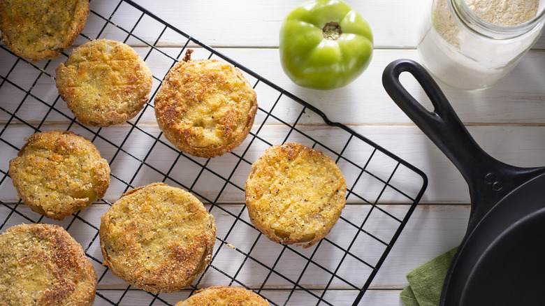 Fried green tomatoes on a wire rack.
