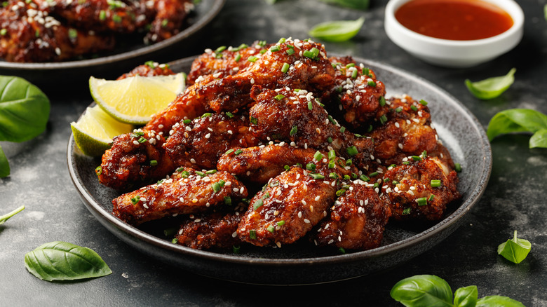 Spicy chicken wings in a plate with lemon wedges