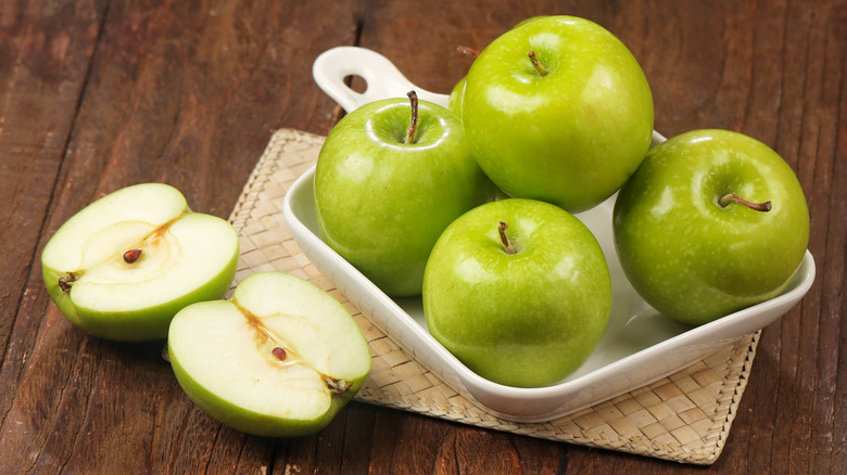 Granny Smith apples on a wooden table.