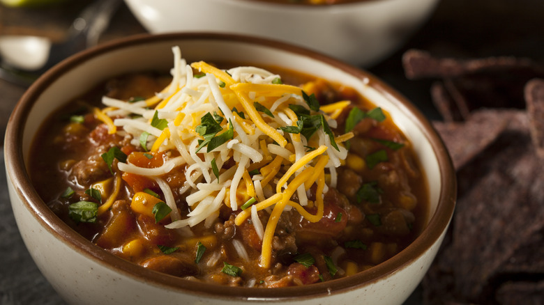 Bowl of chili with cheese and herbs