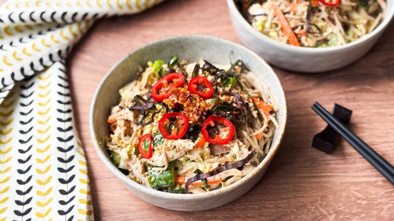 Chilled soba salad with leftover rotisserie chicken in serving bowls with chopsticks and napkin