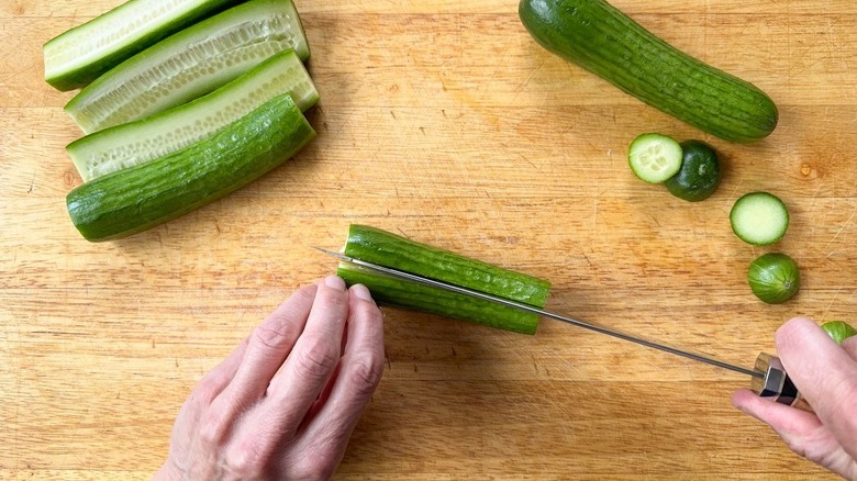 Trimming and halving Persian cucumbers on cutting board