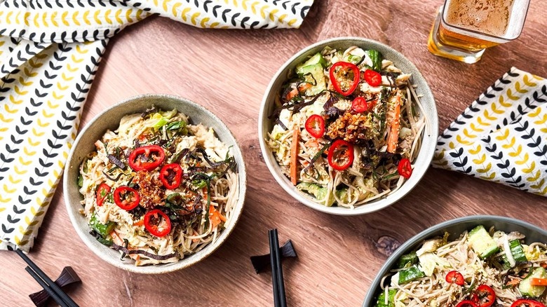 Chilled soba salad with leftover rotisserie chicken in serving bowls with chopsticks and napkins