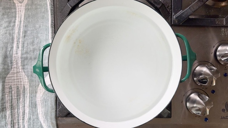 Pot of water on stovetop with green handles