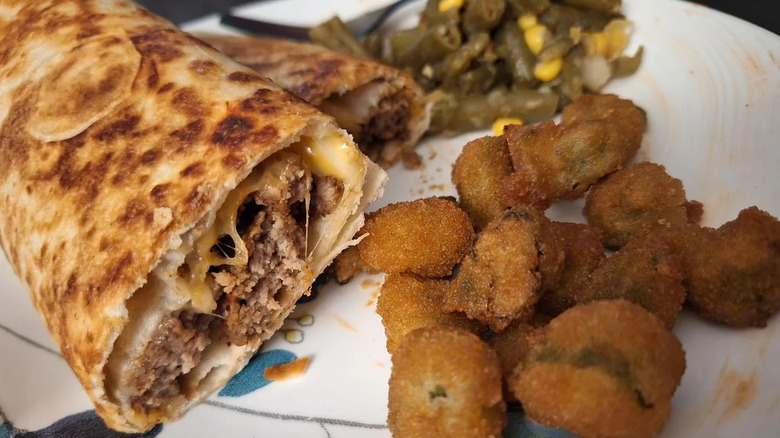 A meatloaf burrito and sides.