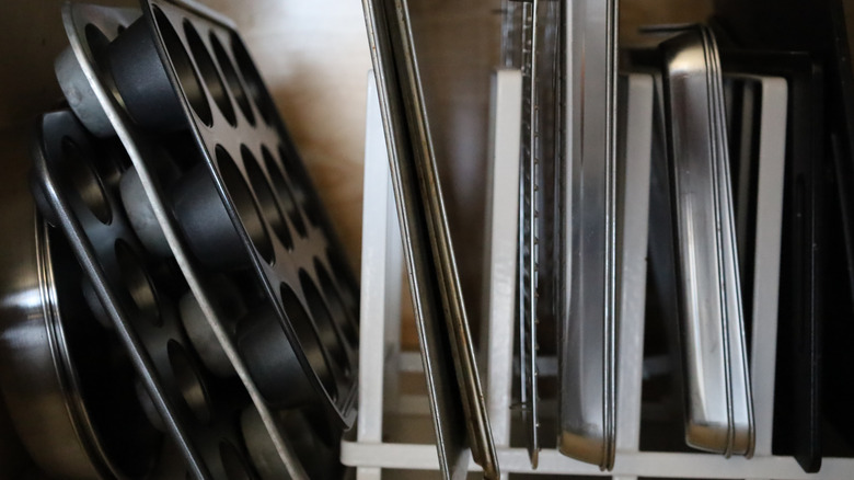 A cabinet full of old baking pans and sheets.