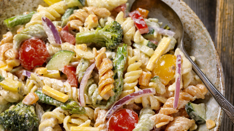 A bowl of pasta salad is photographed in close-up.