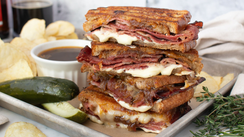 Pastrami French dip sandwich stacked on serving tray