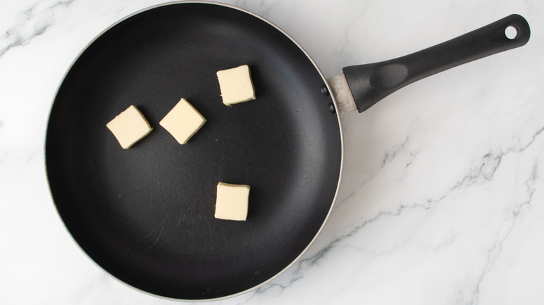 Pats of butter in skillet