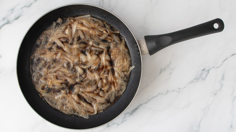 Onions and dark beer in skillet