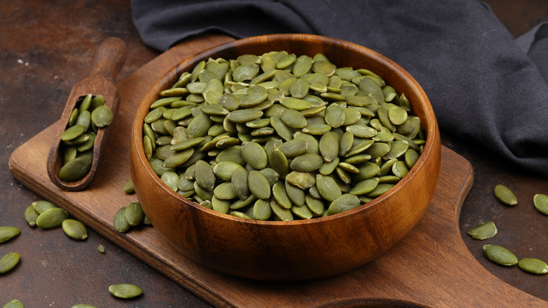 Pumpkin seeds in a wooden bowl.