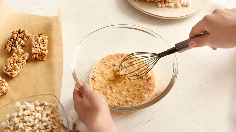 hands mixing bowl of Rice Krispies Treats