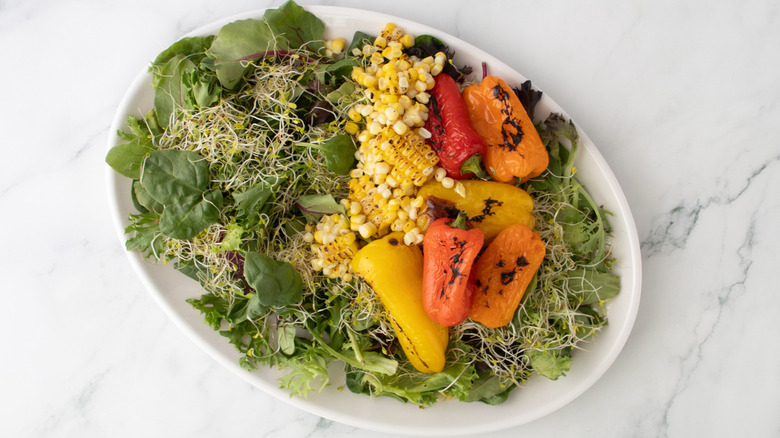 aerial view of vegetables, lettuce, and sprouts in serving dish
