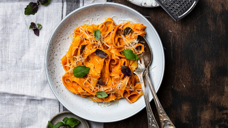creamy pumpkin pasta scattered with leaves